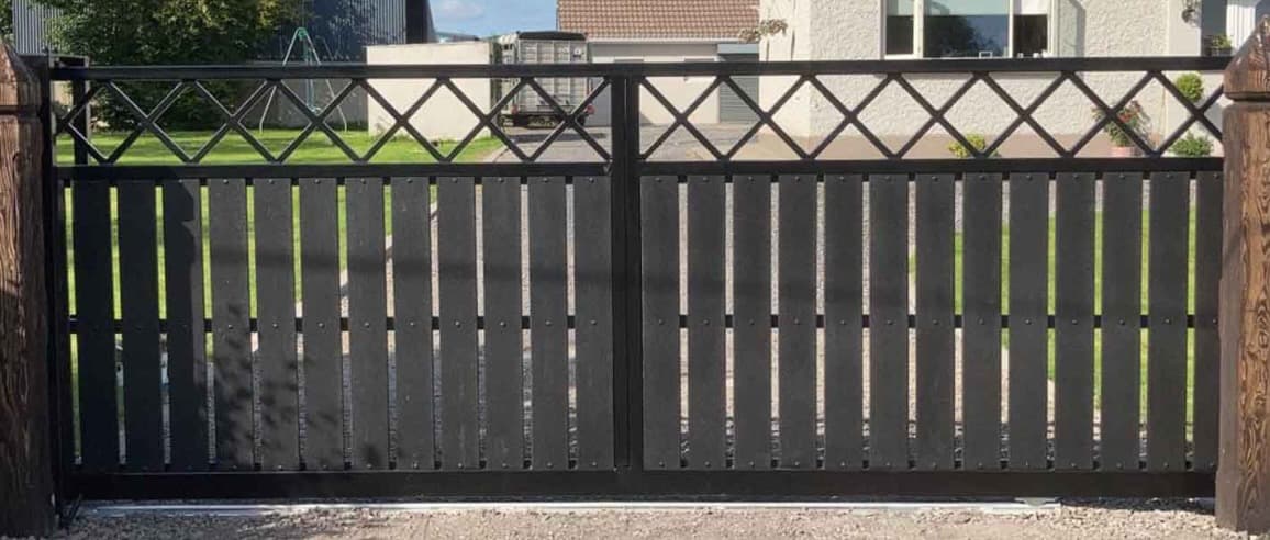 Custom black steel driveway gate installed at a residential entrance